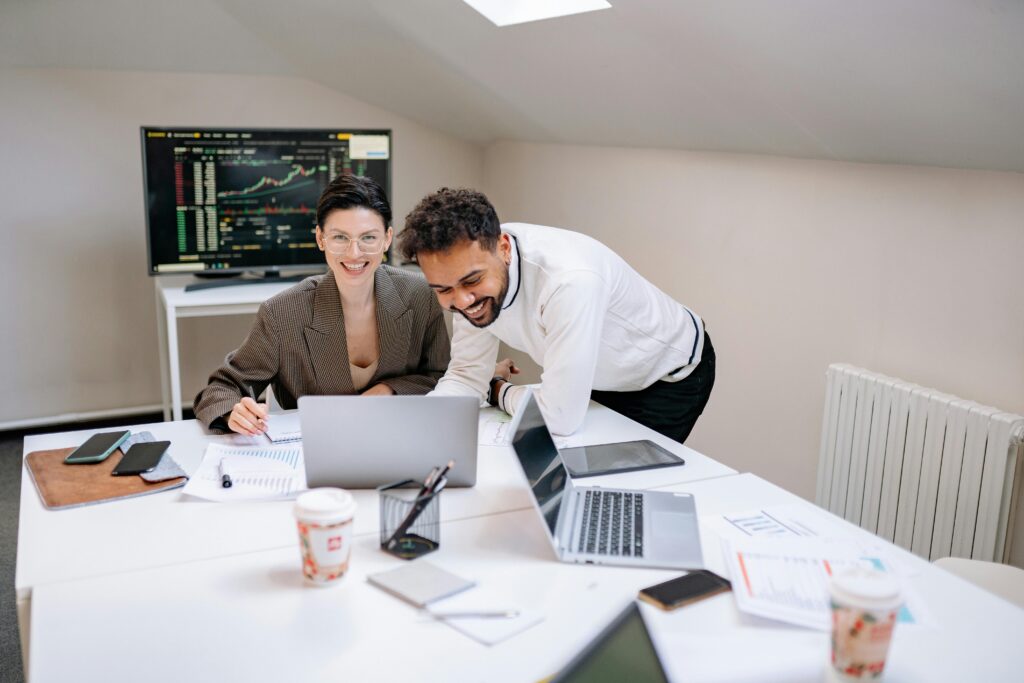 Coworkers reviewing charts and financial performance at a desk, emphasizing the importance of reliable California insurance plans in high-performance business settings.