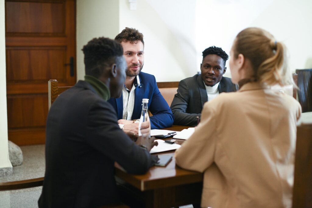 A diverse team engages in a strategy session discussing employee health plans around a conference table.