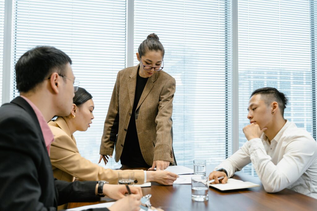 A business meeting in a modern office with four colleagues reviewing documents, representing decision-making for California insurance plans.