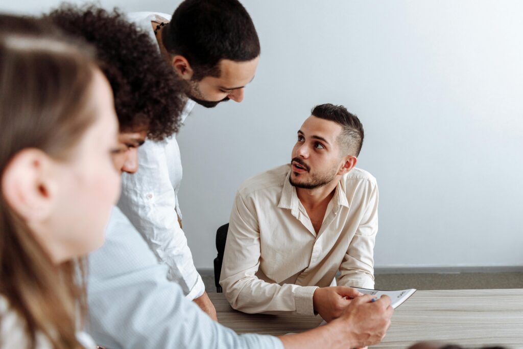 A close-up of coworkers in active conversation during a meeting, collaborating on ideas related to California insurance plans.