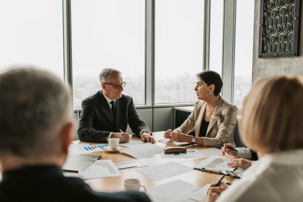 Corporate executives engaged in a strategic planning session with financial documents and charts, highlighting the importance of choosing the right California insurance plans for organizations.